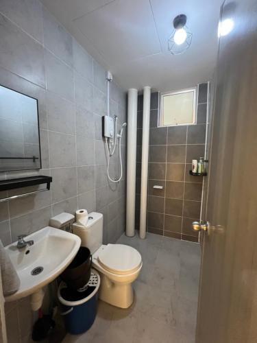 a bathroom with a white toilet and a sink at SweetHome in Ipoh