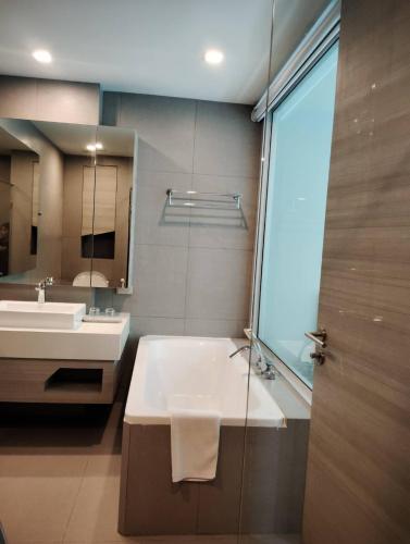 a bathroom with a tub and a sink and a mirror at La Foresta Khaoyai in Pak Chong