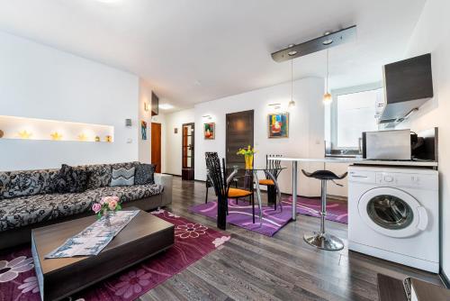 a living room with a couch and a table and a kitchen at Apartments Rosina in Plovdiv