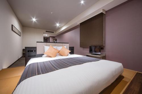 a bedroom with a large white bed with purple walls at HOTEL MYSTAYS PREMIER Kanazawa in Kanazawa