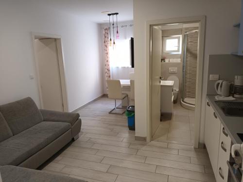 a living room with a couch and a kitchen with a table at Stars Palace Vodice in Vodice