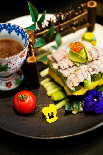 a plate with a sandwich and vegetables and a bowl of soup at Marco Polo Xiamen in Xiamen