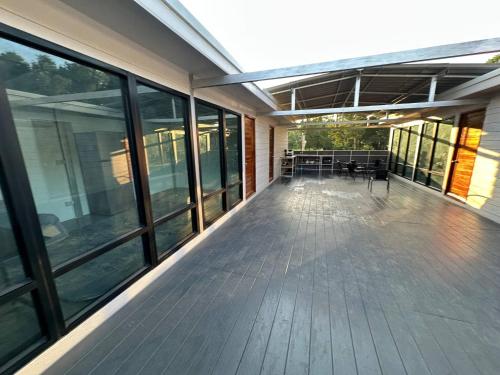 an empty deck of a building with tables and windows at 4 - Private Villa 2BR 1000mbps Wi-Fi in Wok Tum