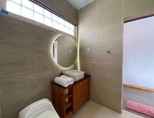 a bathroom with a toilet and a sink and a mirror at Amazing Villa in Seminyak Petitenget Top Location in Seminyak