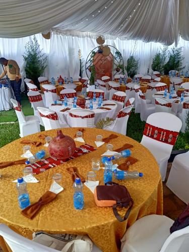 a group of tables and chairs with bottles on them at Camp William's - A dreamer's paradise in Kiambu in Kanyore