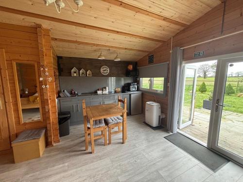 a kitchen with a wooden ceiling and a wooden table at Rife Lodges in Arundel