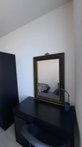 a mirror sitting on top of a black table at Chambre d'hôte, la b&w in Liège