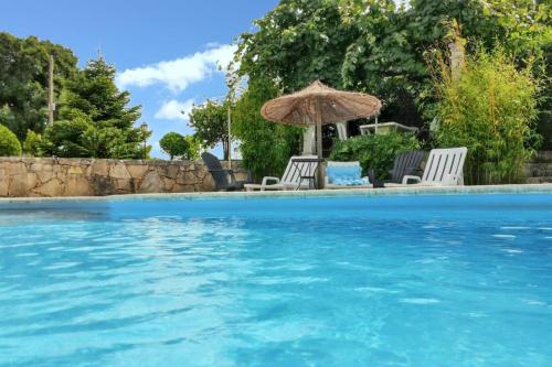 una piscina con sedie e un ombrellone di Charming Villa in Igreja Nova do Sobral with Private Pool a Sobral