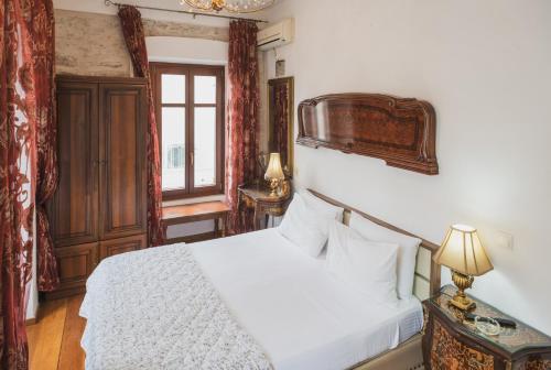 a bedroom with a white bed and a window at Tsopela Boutique Hotel in Skiathos Town