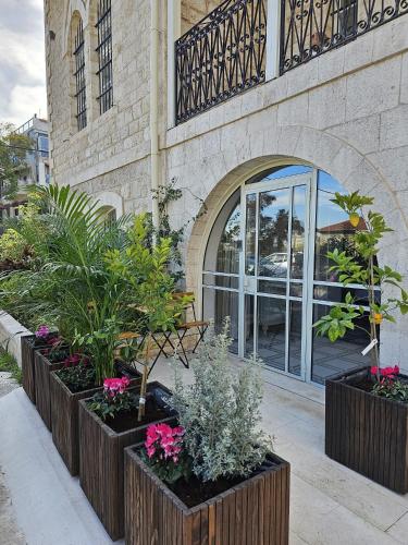 a group of plants in front of a building at כוהנ'ס Cohen's Boutique Hotel in Haifa