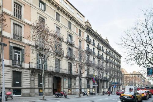 ein großes Gebäude an einer Stadtstraße mit Autos und Motorrädern in der Unterkunft Apartment in downtown Barcelona - Vintage in Barcelona