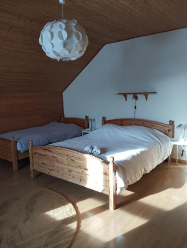 une chambre avec un grand lit et un lustre dans l'établissement Grande maison familiale à Lans en Vercors, à Lans-en-Vercors