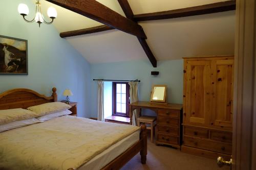 ein Schlafzimmer mit einem Bett, einer Kommode und einem Fenster in der Unterkunft Brynderwen in Llangorse
