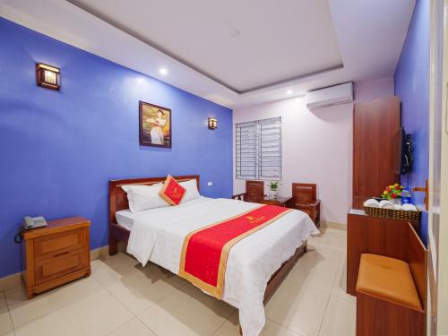 a bedroom with a bed and a blue wall at New An Phú Hotel in Dong Anh