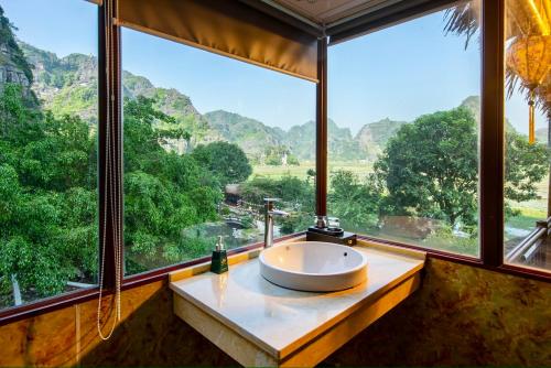 a bathroom with a large window with a sink at Hang Mua Ecolodge in Ninh Binh