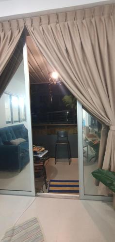 a living room with a couch and a window at Ayesha Metrocity Staycation N-02 & N-5-03 in Kuching
