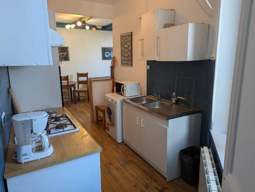 une cuisine avec un évier et une cuisinière four supérieur dans l'établissement Les lunettes d'Oyo 01, à Oyonnax