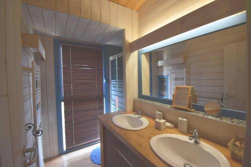 a bathroom with two sinks and a large mirror at Le Séchoir Aquitain, logement insolite in Dolmayrac