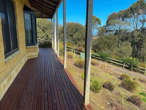 a porch of a house with a wooden walkway at Banksia in Port Campbell
