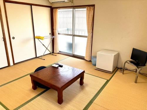 a living room with a coffee table and a television at ビジネスホテル美咲 in Sakaide