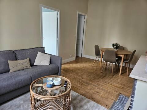 un salon avec un canapé et une table dans l'établissement La Goéliane - Appartement 2 chambres proche mer, à Wimereux