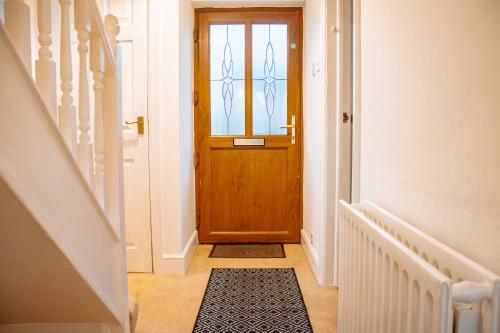 a hallway with a wooden door and a rug at Spacious 4-Bed Home in Wetherby in Wetherby