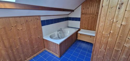 La petite salle de bains est pourvue de portes en bois et d'une baignoire. dans l'établissement Grande maison familiale à Lans en Vercors, à Lans-en-Vercors