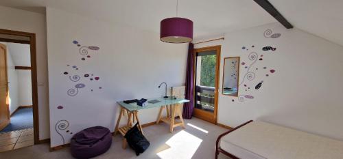 une chambre avec une table et un mur avec des autocollants dans l'établissement Grande maison familiale jusqu'à 14 personnes à Lans en Vercors, à Lans-en-Vercors