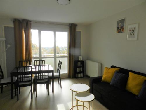 un salon avec un canapé et une table dans l'établissement Appartement lumineux Rennes, à Rennes