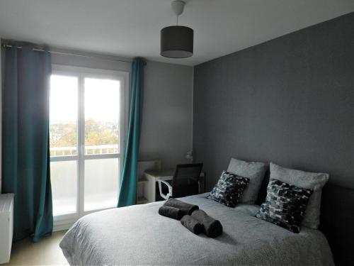 une chambre avec un lit avec une grande fenêtre dans l'établissement Appartement lumineux Rennes, à Rennes