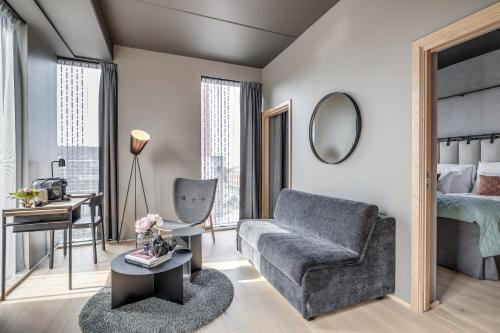 a living room with a couch and a bedroom at Quality Hotel Hasle Linie in Oslo