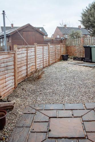 a backyard with a wooden fence and a stone patio at Spacious 4-Bed Home in Wetherby in Wetherby