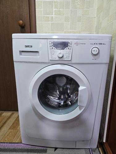 a white washing machine sitting in a room at Guesthouse Mirlan in Karakol
