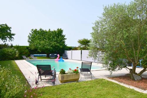 una piscina con due sedie e un fenicottero rosa di Gîte l'Ostalet de Sarron à Brax, Lot et Garonne a Brax