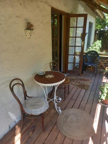 a patio with a table and chairs on a porch at Emerald Hill Cottage in Mount Pleasant