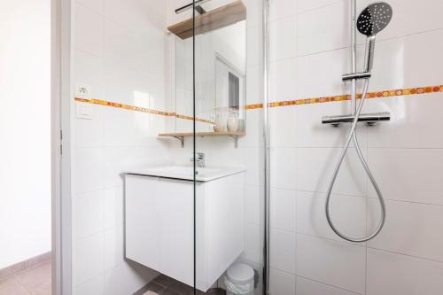 une douche avec une porte vitrée dans une salle de bain dans l'établissement Appartement entre montagne et océan, à Biriatou