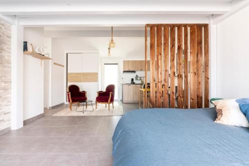une chambre avec un lit bleu et une cuisine dans l'établissement Appartement entre montagne et océan, à Biriatou