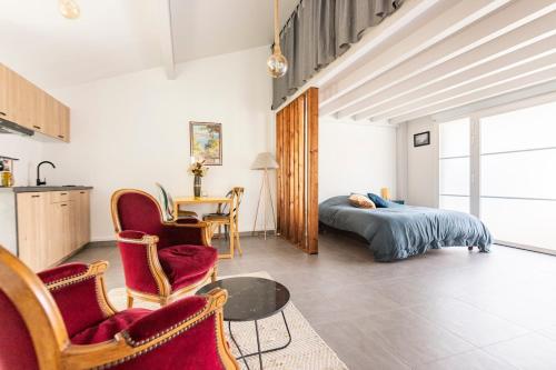 une chambre avec un lit, une table et des chaises dans l'établissement Appartement entre montagne et océan, à Biriatou