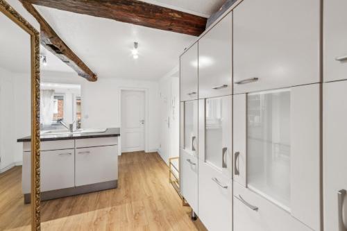 a kitchen with white cabinets and a sink at Fleth-Quartier Glückstadt in Glückstadt