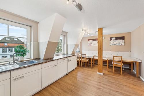 a kitchen and dining room with white cabinets and a table at Fleth-Quartier Glückstadt in Glückstadt