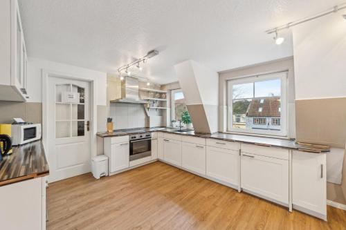 a kitchen with white cabinets and a large window at Fleth-Quartier Glückstadt in Glückstadt
