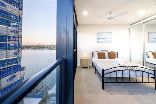 a bedroom with a bed and a view of the water at Central 2BR-2BA Resort-Style Retreat In Hamilton M21 in Brisbane