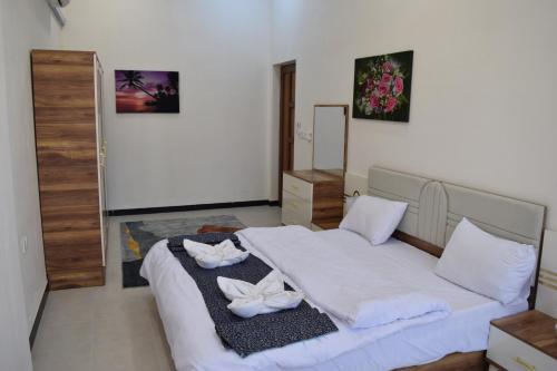 a bedroom with a bed with two towels on it at شقق دار الزيني - Dar Alzainy Apartments in Baghdad