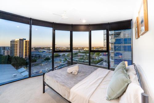 a bedroom with a bed and large glass windows at Central 2BR-2BA Resort-Style Retreat In Hamilton M21 in Brisbane
