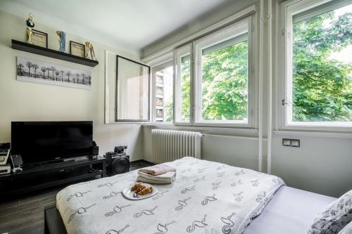 a bedroom with a bed with a plate of food on it at Basilica Downtown AC & Metro in Top Location in Budapest