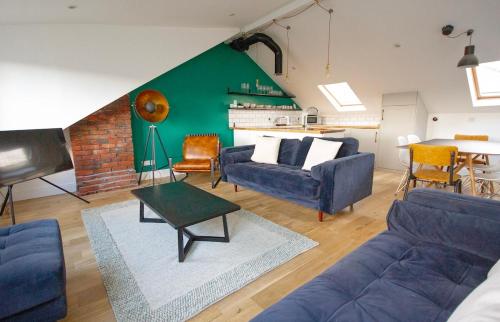 a living room with a blue couch and a piano at The Loft Winchester in Winchester