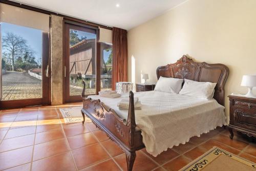 a bedroom with a bed and a large window at Quinta Da Ataíde in Rendufe