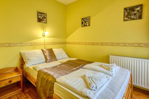 a yellow bedroom with two beds in it at Pihenőkereszt Panzió in Sopron