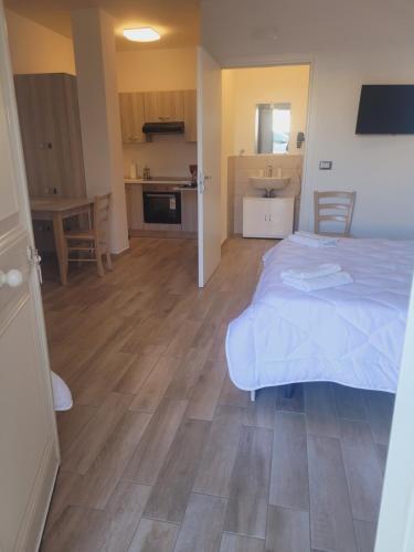 a bedroom with a large bed and a kitchen at HOUSE AIRPORT Catania in Catania