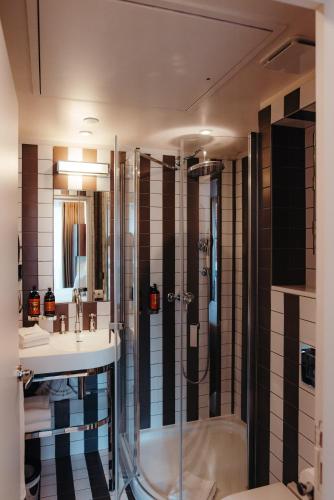 ein Badezimmer mit Dusche und Waschbecken in der Unterkunft Hotel Eiffel Blomet in Paris